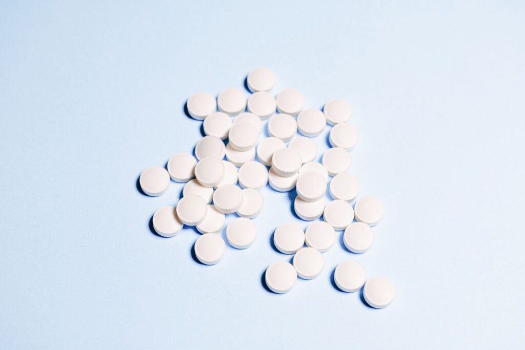White round medication tablets on a soft blue surface representing weight-loss medicines