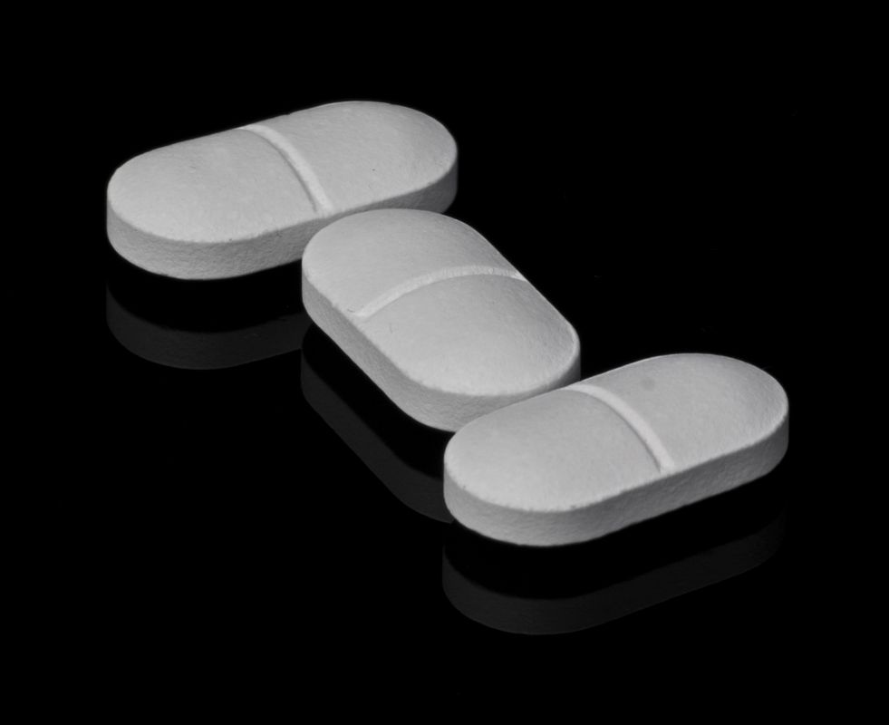 White weight loss tablets on a dark surface